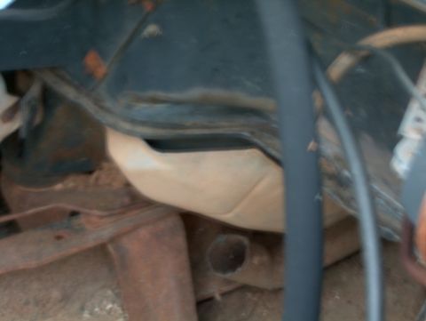 1979 Ford Bronco - Underside view of engine bay components, showing hoses and rusty metal structures.