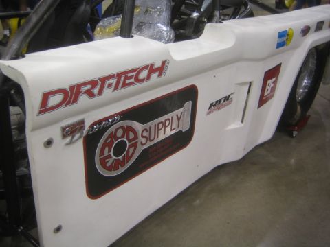 1990 Ford Bronco - white off-road race body panel displays Dirt-Tech lettering and a Rod End Supply decal alongside other sponsor stickers.