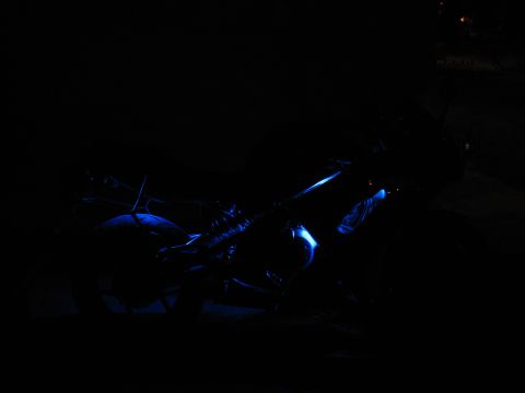 2007 Kawasaki Ninja - A motorcycle is illuminated by blue lights in the dark.