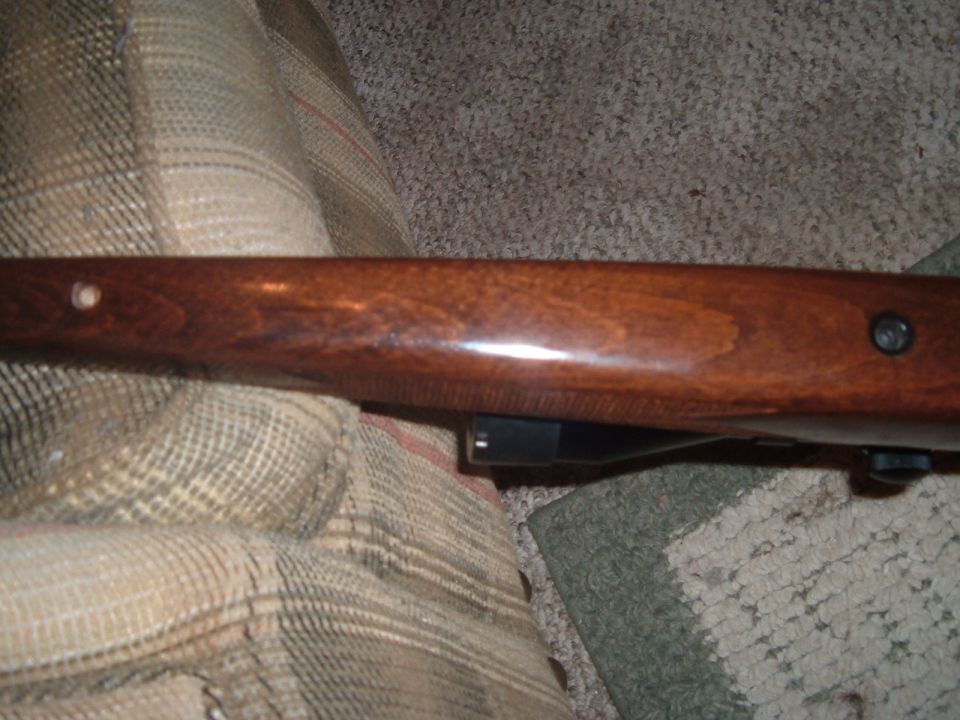 Wooden rifle stock with visible screw and hole