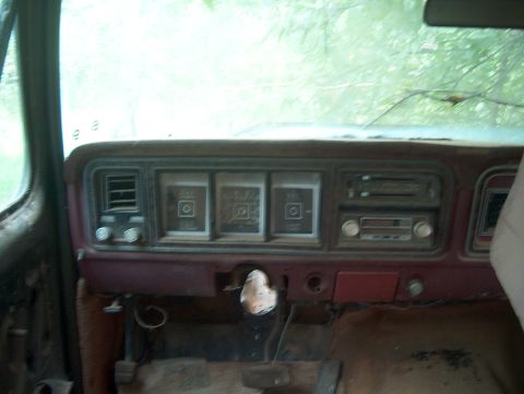 1979 Ford Bronco - The interior of a 1979 Ford Bronco shows a worn dashboard with visible gauges and radio.