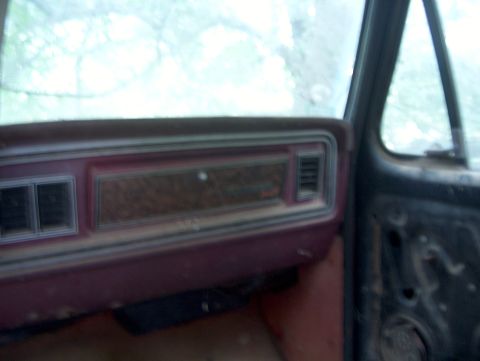 1979 Ford Bronco - The interior of a 1979 Ford Bronco shows its dashboard with wood grain trim and maroon accents, suggesting a vintage vehicle.