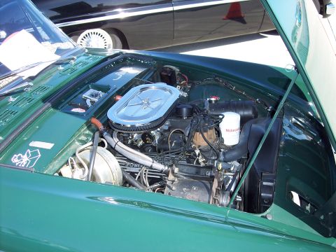1971 Ford Mustang - Engine bay detail of a green car, with another vehicle visible behind it.