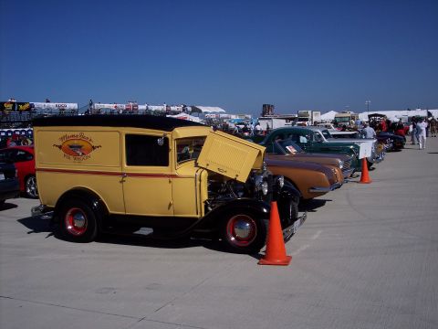 1971 Ford Mustang - A vintage yellow panel van with 'Mama Bear Pie Wagon' text is parked at an outdoor event.