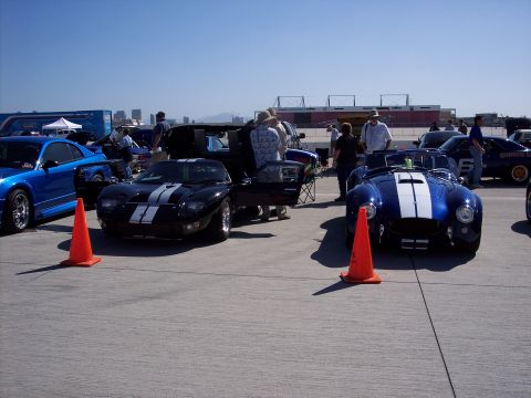 1971 Ford Mustang - Two classic sports cars, a Ford GT and a Shelby Cobra, are displayed outdoors on a sunny day.