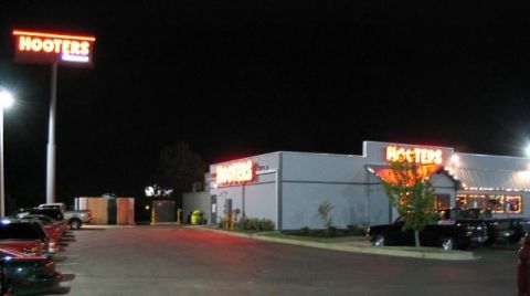 1999 Ford Crown Victoria - A nighttime scene shows several vehicles parked in the lot of a Hooters restaurant, with its prominent signage illuminated.