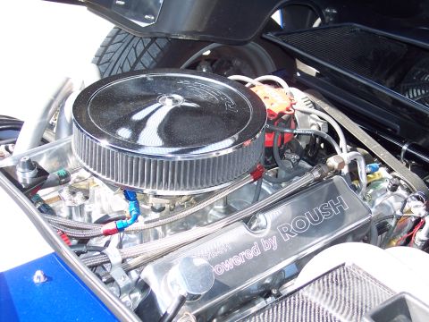 1971 Ford Mustang - Close-up of a custom engine bay a large chrome air filter and "ROUSH" branded valve covers.