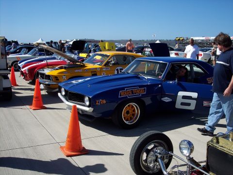 1971 Ford Mustang - A blue 1969 Chevrolet Camaro Z/28 race car, part of a line-up of vintage vehicles, displays its racing livery.