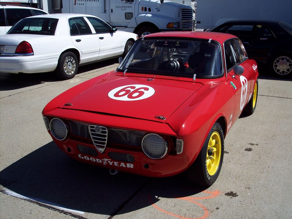 Red racing car with number 66 on hood, yellow wheels, and Goodyear sticker on front bumper