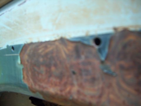 1979 Ford Bronco - Close-up of a heavily rusted metal panel, showing signs of decay and damage.
