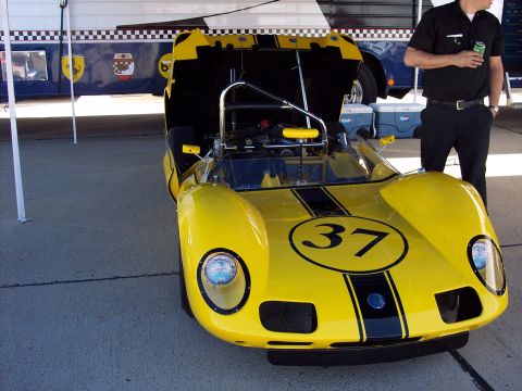 1971 Ford Mustang - Front view of a yellow race car, number 37, with its hood open, revealing the engine.