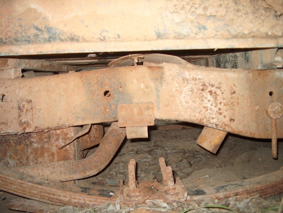 rusted vehicle frame and leaf springs, showing undercarriage components