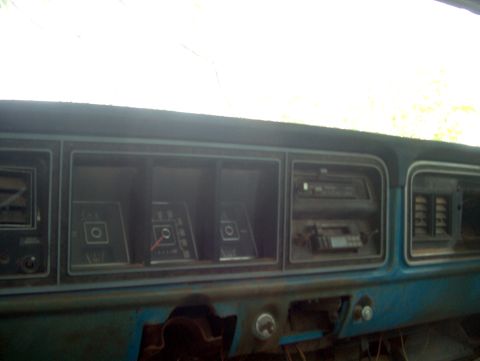 1979 Ford Bronco - The interior of a 1979 Ford Bronco shows a blue dashboard with various gauges and radio slots.