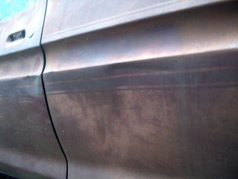 1979 Ford Bronco - The side panel of an older vehicle shows signs of wear and discoloration.