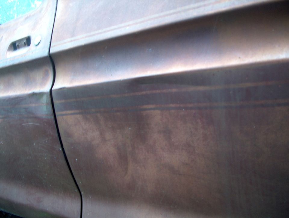 close-up of a brown vehicle door with a handle and body lines