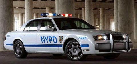1999 Ford Crown Victoria - This police car, marked with NYPD and 'POLICE', has a distinctive grille and body style.