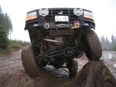 1989 Ford Bronco - This modified truck is navigating an obstacle on a wet, off-road course.