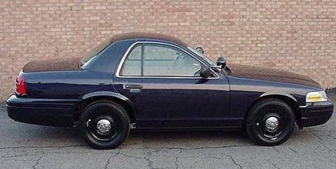 1999 Ford Crown Victoria - Side profile of a dark blue Ford Crown Victoria Police Interceptor with black steel wheels and a spotlight, rendered as a shortened two-doo…