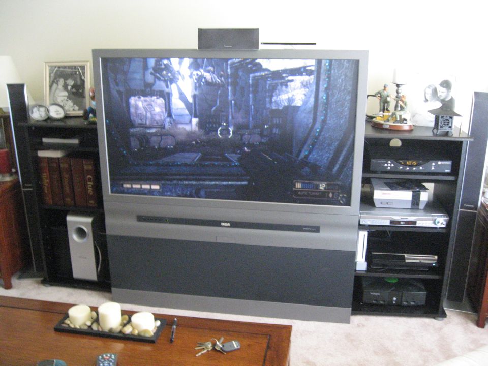 Television screen displaying a video game, with entertainment center and speakers