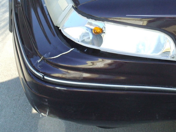 Dark purple 1992 Ford Crown Victoria front bumper with damage and chrome trim