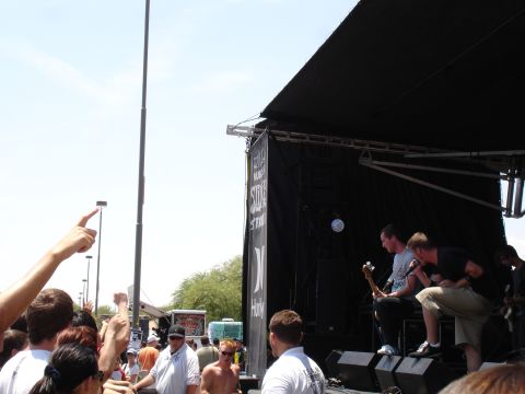 1992 Ford F-150 - A band plays on a stage at an outdoor event, with a crowd gathered to watch.