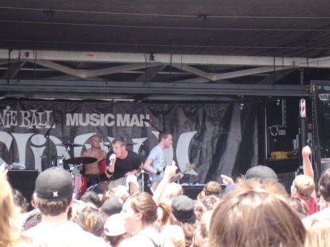 1992 Ford F-150 - A band performs live on stage for an audience, with a "Music Man" banner behind them.