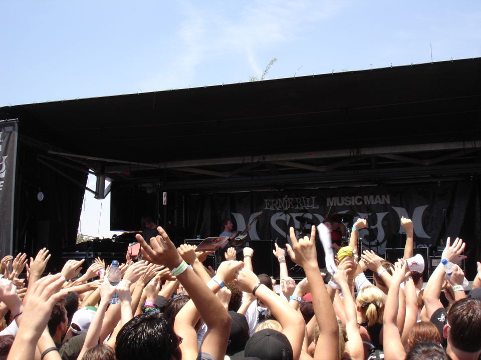Concert crowd with hands raised in front of a stage