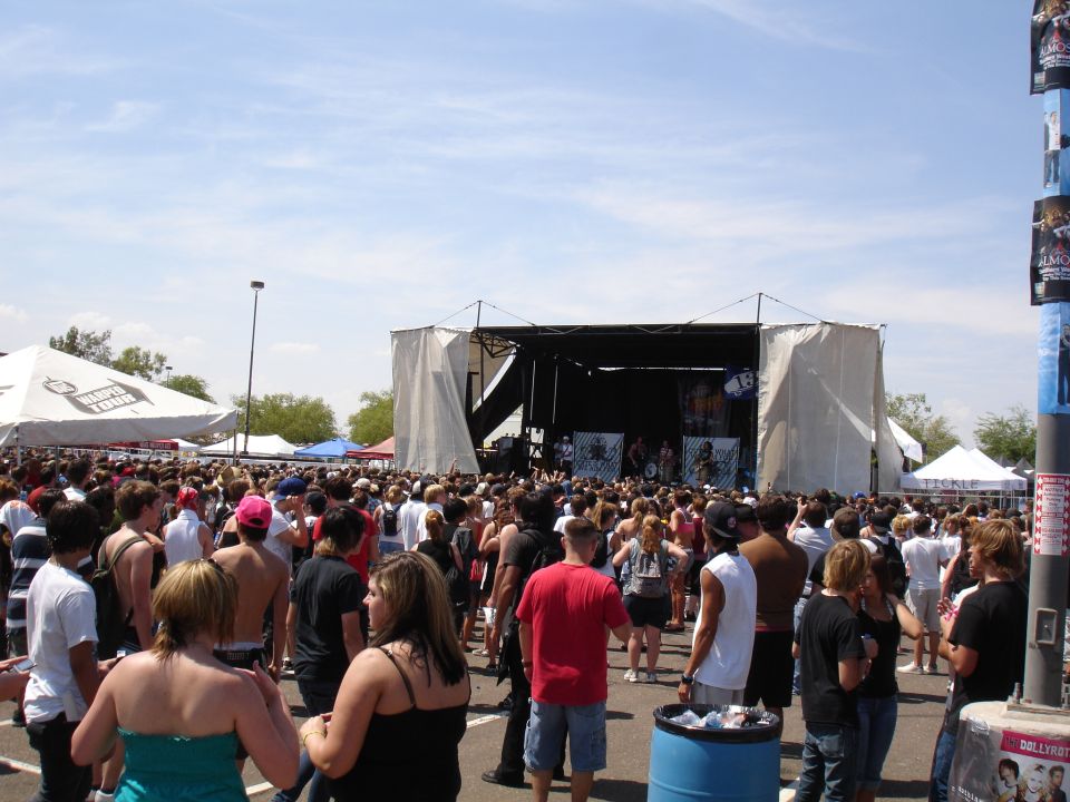 Crowd gathered for an outdoor concert with a stage set up