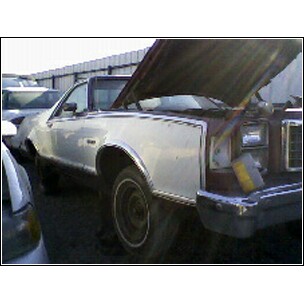 1973 Ford Ranchero - A 1973 Ford Ranchero sits in a yard with its hood open, revealing the engine compartment.