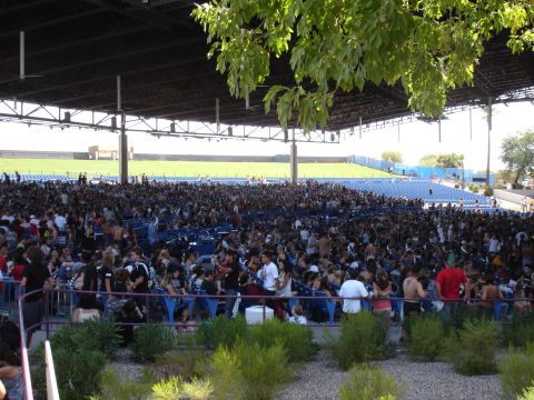 1992 Ford F-150 - A large crowd fills the seating and standing areas of an outdoor amphitheater during a concert.