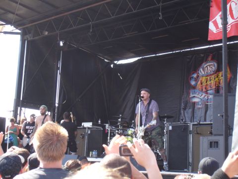 1992 Ford F-150 - A band performs live on stage at the Vans Warped Tour, with a banner and crowd visible.