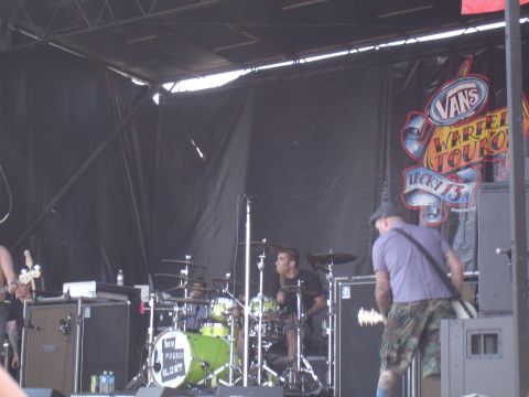 1992 Ford F-150 - A band plays on stage during the Vans Warped Tour, with a banner visible behind them.