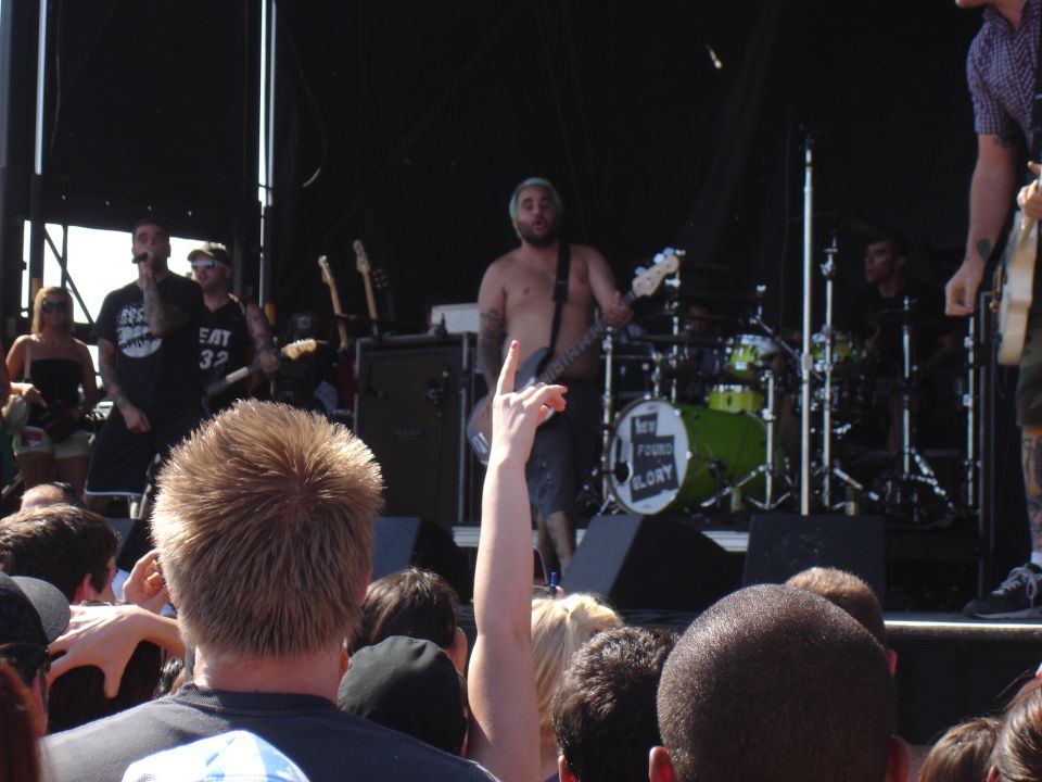 Band performing on stage with drums and guitars visible