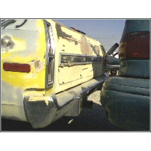 1973 Ford Ranchero - This yellow vehicle appears to be in a state of disrepair, possibly at a junkyard.