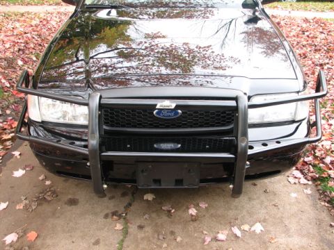 2000 Ford Crown Victoria - A black 2000 Ford Crown Victoria is shown from the front, equipped with a protective push bar.