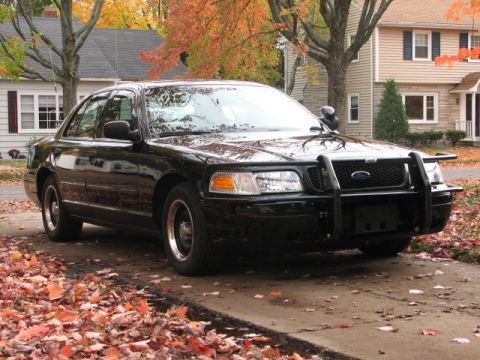 2000 Ford Crown Victoria - A black 2000 Ford Crown Victoria police car is parked on a driveway during autumn.
