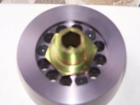 1989 Ford Bronco - This is a close-up view of an automotive part with a hexagonal yellow metal insert and surrounding black bolts.