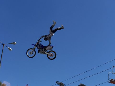 1989 Ford Bronco - A motocross rider is airborne, executing a trick on their dirt bike.
