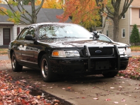 2000 Ford Crown Victoria - A black 2000 Ford Crown Victoria Police Interceptor is parked on a driveway with autumn leaves scattered around.