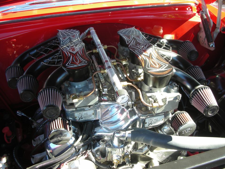 Dual-quad chrome V8 engine with custom black flame-painted air intakes and K&N filters