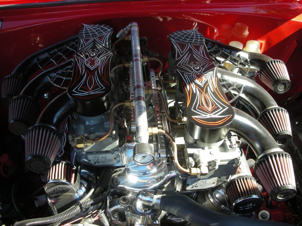 Polished dual-carburetor V8 engine with custom flame-painted intake covers and cone filters