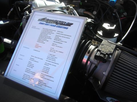 1998 Ford Crown Victoria - Framed display spec sheet for a 2001 SVT Ford Lightning sitting in the engine bay, listing build modifications.
