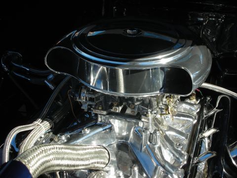 1998 Ford Crown Victoria - Close-up of a brightly polished chrome V8 engine topped by a large round air cleaner with braided stainless steel hoses.