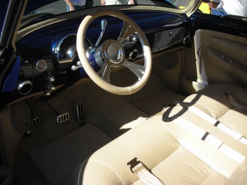1998 Ford Crown Victoria - Customized car interior featuring tan leather upholstery, brushed-finish four-spoke wheel and chrome dash accents.