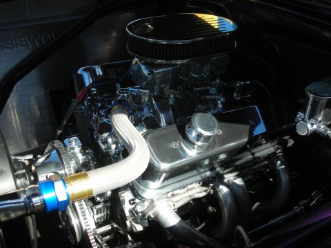 1998 Ford Crown Victoria - Detailed chrome small-block V8 engine with a finned oval air cleaner and white braided exhaust header wrap.