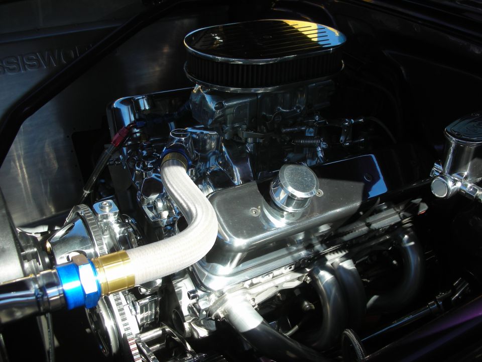 Chrome small-block V8 engine with finned air cleaner and braided header lines