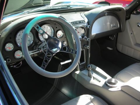 1998 Ford Crown Victoria - Restomod Corvette interior featuring gray leather seats, machined-bezel gauges and a painted three-spoke steering wheel.