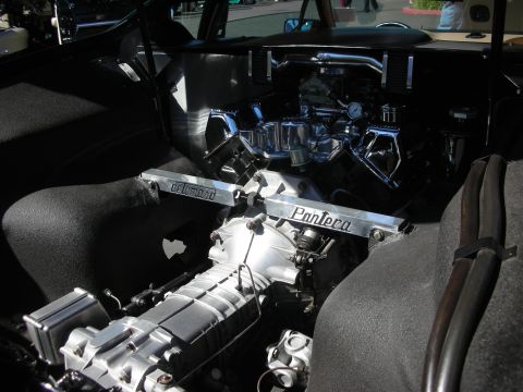 1998 Ford Crown Victoria - rear-mid engine bay with a supercharged chrome-topped V8 and a polished strut brace engraved De Tomaso Pantera.