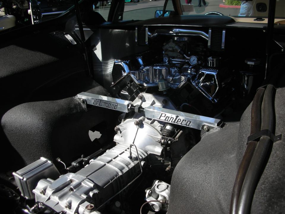 Rear-mounted supercharged V8 with chrome covers and Pantera strut brace