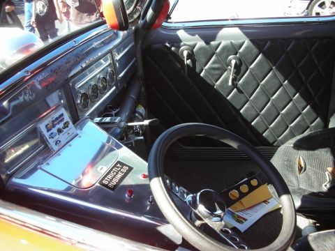 1998 Ford Crown Victoria - Interior of a custom hot rod showing a right-hand-drive steering wheel, floor shifter, and black diamond-stitched upholstery.